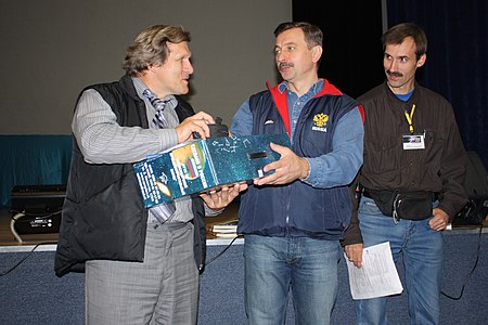 СибАстро-2009. Участник форума В. Крупко (слева) получает телескоп из рук космонавта А. И. Лазуткина (в центре).