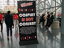 Tall black standing sign with the phrase "Cosplay Is Not Consent" in large lettering, alongside New York Comic Con branding and further explanatory text in smaller lettering.