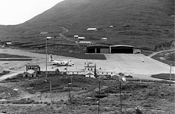 Veduta dellꞌarea della rampa del Dutch Harbor con un velivolo USCG C-130 Hercules in attesa per un volo di emergenza.