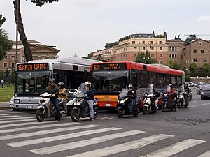 Buses, motorcycles, and cars are common in Rome.