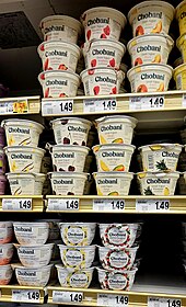 Grocery store shelf with dozens of single servicing yogurt containers.