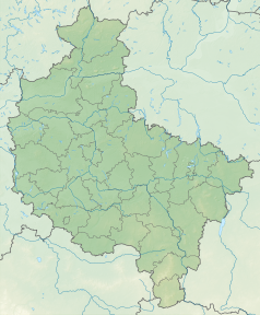 Mapa konturowa województwa wielkopolskiego, blisko lewej krawiędzi znajduje się owalna plamka nieco zaostrzona i wystająca na lewo w swoim dolnym rogu z opisem „Jezioro Wąchabnowskie”