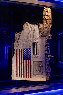 A portion of the Challenger's fuselage hanging vertically, displaying the American flag.