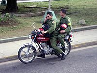 Dois militares cubanos em uma moto.