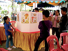 在老挝举办的学习节上，在桌子上摆放了贴有人类生殖系统插画的硬板。两个孩子正在阅读这些内容。