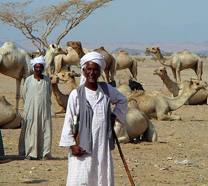 Un beduin în deșertul Sudanului în haina tradițională albă și cu turban alb