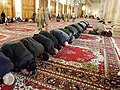 Muslimskir menn í bøn inni í mosku.