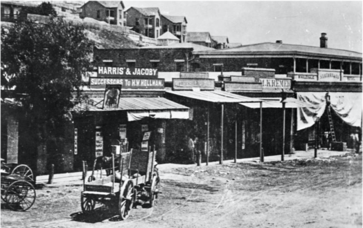 Sign for "Harris & Jacoby, successors to H. W. Hellman", forerunner to both Harris & Frank and Jacoby Bros., in the Old Downey Block around 1870. At right are signs for M. Kremer's and S. Lazard's stores, both forerunners of the City of Paris department store