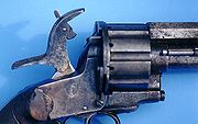 A close-up of the hammer on a LeMat Pinfire Revolver shows the pivoting striker that could be used to fire the pinfire cartridges in the revolving chambers or the secondary smoothbore barrel.[3]