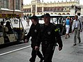 שני שוטרים (מדי סיור ישנים) מסיירים בכיכר השוק העתיקה של קרקוב