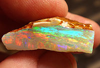 Opala de cristal áspero multicolorido de Coober Pedy, Austrália do Sul, expressando quase todas as cores do espectro visível