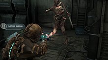 A man in a futuristic suit fights a monster in a darkened corridor.
