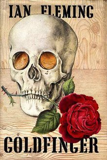 Cover showing a rose held in the teeth of a skull with gold coins for eyes. At the top is the name "IAN FLEMING"; at the bottom is "GOLDFINGER".