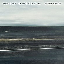 A mostly charcoal grey, lightly blue painting of coal mountains backdropped against a overcast sky. The words "Public Service Broadcasting" and "Every Valley" are written in bold black font on the top left and top right corners of the image, respectively. It is titled "Viaduct', and was painted by Hannah Benkwitz.