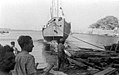 דלין (אוניית מעפילים) יורדת למים בברכת הבישוף של מונופולי והגב' ג'יקלה פרמדר רעייתו של רב החובל אנריקו לוי, 3 באוגוסט 1945. – באדיבות "אוצר תמונות הפלמ"ח"