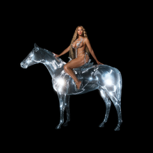 Một người phụ nữ da đen trong bộ đồ tắm bằng kim loại có gai ngồi trên đầu một con ngựa pha lê