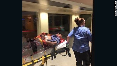 The suspect in the attack on TSA agents at the New Orleans-area airport is taken away on a stretcher.