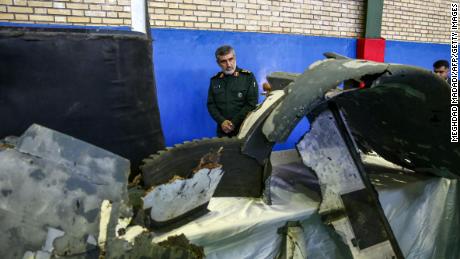 General Amir Ali Hajizadeh (C), Iran&#39;s Head of the Revolutionary Guard&#39;s aerospace division, looks at debris from a downed US drone reportedly recovered within Iran&#39;s territorial waters and put on display by the Revolutionary Guard in the capital Tehran on June 21, 2019. - Iran&#39;s state television broadcast images of what it said was debris from a downed US drone recovered inside its territorial waters. The television broadcast a short clip of a Revolutionary Guards general answering questions in front of some of the debris he said had been recovered after yesterday&#39;s missile strike. The downing of the drone -- which Washington insists was over international waters but Tehran says was within its airspace -- has seen tensions between the two countries spike further after a series of attacks on tankers the US has blamed on Iran. (Photo by Meghdad Madadi / TASNIM NEWS / AFP)        (Photo credit should read MEGHDAD MADADI/AFP/Getty Images) 