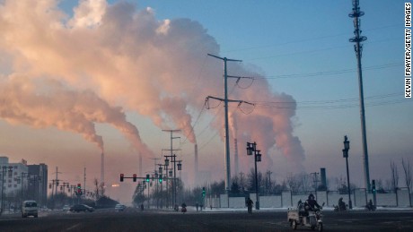 SHANXI, CHINA -NOVEMBER 25: (CHINA, HONG KONG, MACAU, TAIWAN OUT)  Chinese workers commute as smoke billows from a coal fired power plant on November 25, 2015 in Shanxi, China. A history of heavy dependence on burning coal for energy has made China the source of nearly a third of the world&#39;s total carbon dioxide (CO2) emissions, the toxic pollutants widely cited by scientists and environmentalists as the primary cause of global warming. China&#39;s government has publicly set 2030 as a deadline to reach the country&#39;s emissions peak, and data suggest the country&#39;s coal consumption is already in decline. The governments of more than 190 countries are expected to sign an agreement in Paris to set targets on reducing carbon emissions in an attempt to forge a new global agreement on climate change.  (Photo by Kevin Frayer/Getty Images)