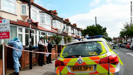 Police and forensic officers attend the scene where a pregnant women was stabbed to death in south London in the early hours of June 29.