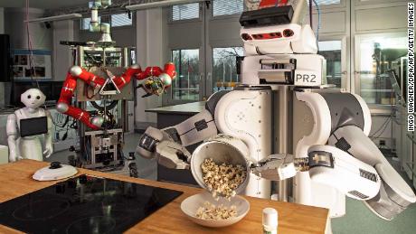 A robot pours popcorn from a cooking pot into a bowl on March 8, 2017 at the Institute for Artificial Intelligence (AI) of the university of Bremen, northwestern Germany.
Scientists of the institute work among others on &quot;AI-based control methods for robotic agents, performing human-scale everyday manipulation-task&quot;, and investigate &quot;computing systems that assist humans at home, at work and during leisure activities&quot;. / AFP PHOTO / dpa / Ingo Wagner / Germany OUT        (Photo credit should read INGO WAGNER/AFP/Getty Images)