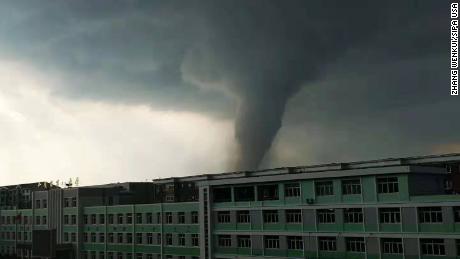 A tornado sweeps through residential buildings and streets in Kaiyuan city on 3 July 2019.