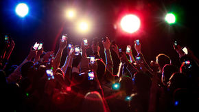 A crowd of people holding up their phones