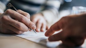 hands signing a contract