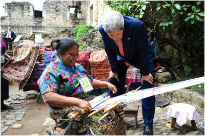 Secretary of State John Kerry examines goods made by a textile worker during a break in an Organization of American States meeting.