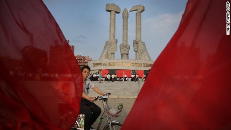 A North Korean man cycles past the Workers&#39; Party monument while framed by red party flags in Pyongyang, North Korea on Sunday, June 19, 2016. North Koreans celebrated the entry of their former leader Kim Jong Il&#39;s entry to the Central Committee of the Workers&#39; Party of Korea in 1964. (AP Photo/Wong Maye-E)