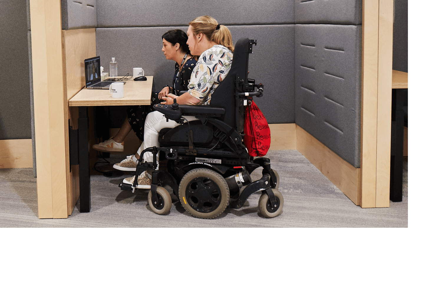 Two BBC employees in an accessible meeting booth.