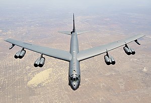 Aerial top/side view of gray B-52H flying over Texas