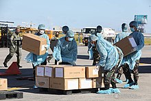 Workers unloading boxes of medical supplies at Villamor Air Base.
