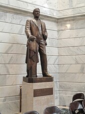 A bronze sculpture of Vice President Alben W. Barkley standing atop a marble base, as seen inside the rotunda of the Kentucky State Capitol