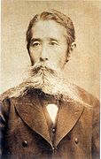 photo portrait d'un homme japonais de face en costume occidental, arborant une imposante moustache.