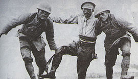 Japán katonák segítenek egy sebesült bajtársuknak elhagyni a csatateret.