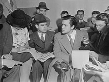 Photograph of Orson Welles surrounded by reporters