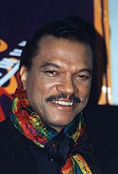 A smiling Billy Dee Williams looking directly at the camera