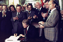 Carter surrounded by a crowd of people as he signs the Airline Deregulation Act.