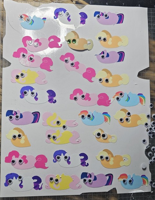 my little pony stickers with googly eyes. some are ripped and rumpled and the googlies are going everywhere