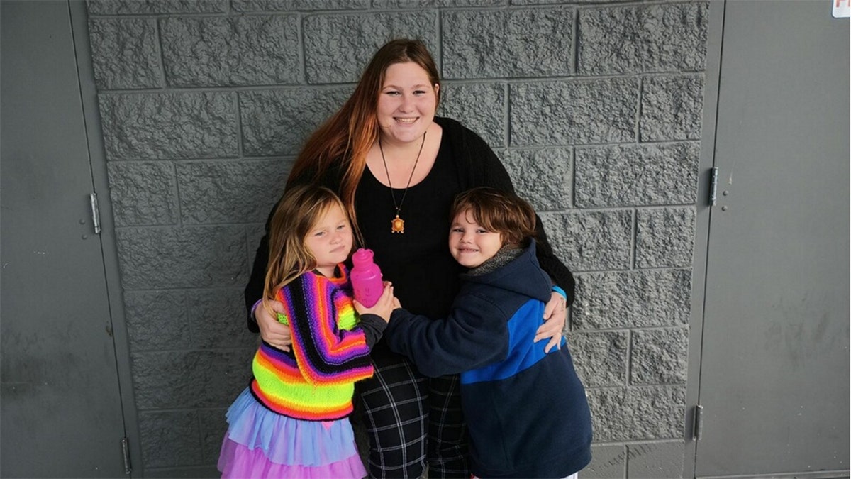 Rain Mancini holding her two children