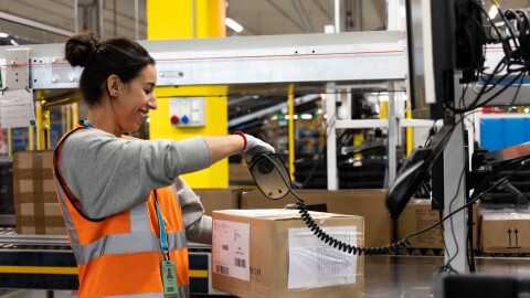 Trabajadora de Amazon escanendo un paquete. 