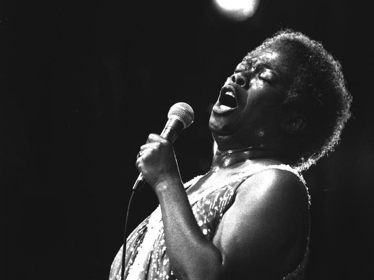 Schwarzweißfotografie von Sarah Vaughan, die auf der Bühne singt