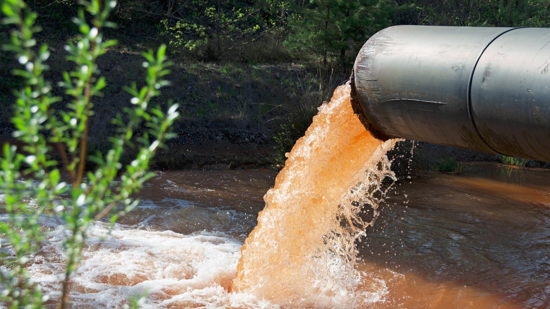 Ein Rohr leitet Abwasser in einen Fluss