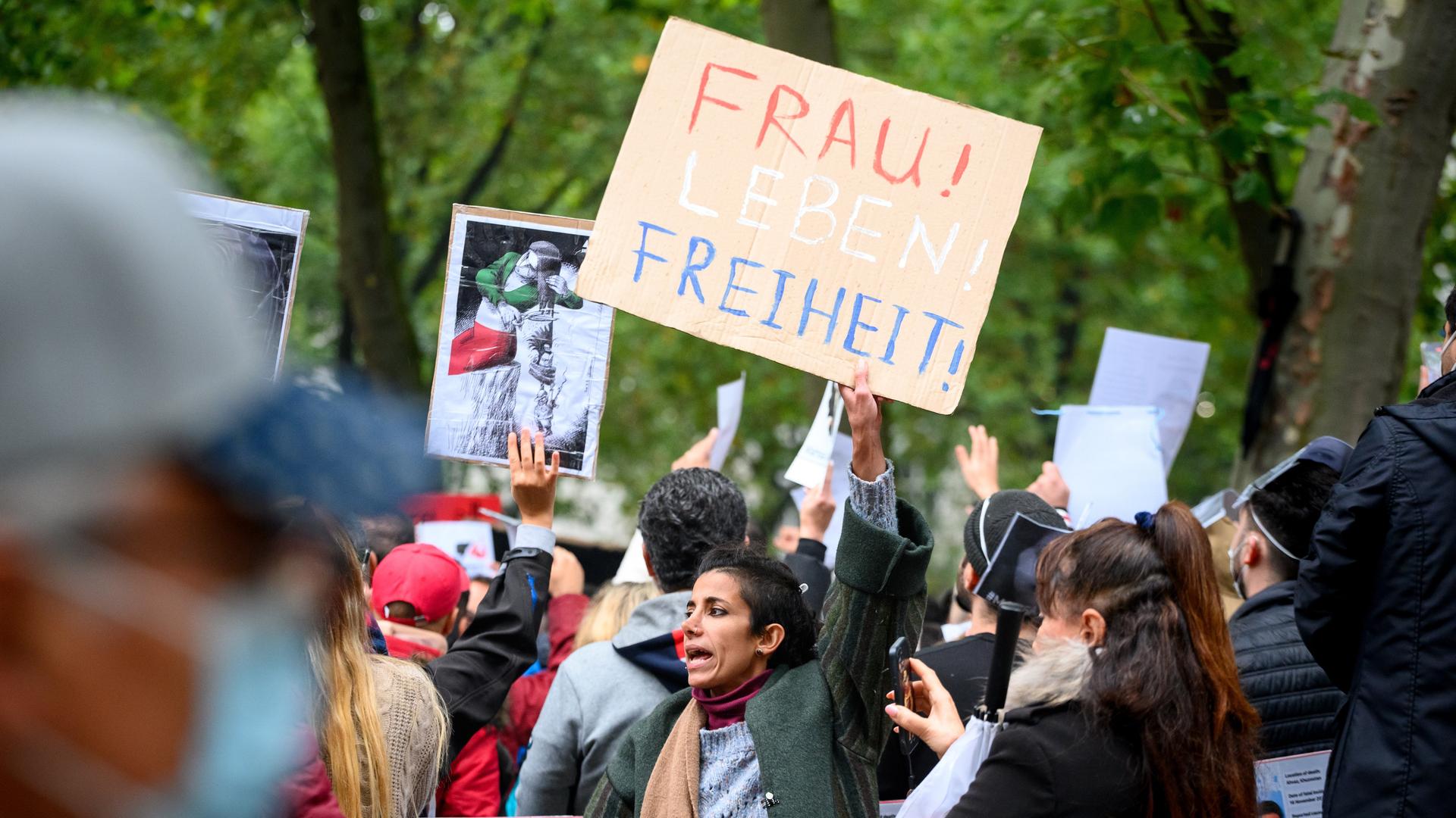 Eine Frau schreit eine Parole und zeigt ein Plakat mit der Aufschrift "Frau! Leben! Freiheit!" auf einer Solidaritätskundgebung nach dem Tod der Kurdin Jina (Mahsa) Amini, die in der vergangenen Woche im Iran nach ihrer Verhaftung durch die dortige Sittenpolizei gestorben war.