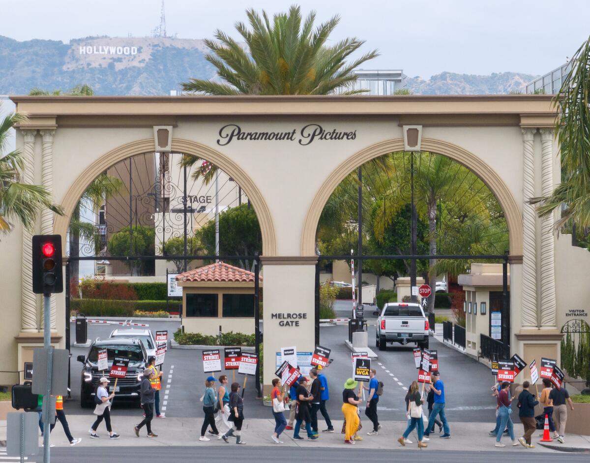 People march on a picket line outside the Melrose Avenue gate of Paramount Studios