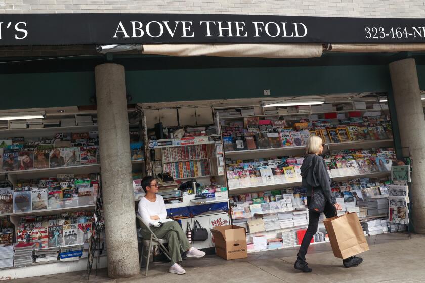 Los Angeles, CA - September 19: A woman walks by the Above the Fold newsstand on Thursday, Sept. 19, 2024 in Los Angeles, CA. (Michael Blackshire / Los Angeles Times)