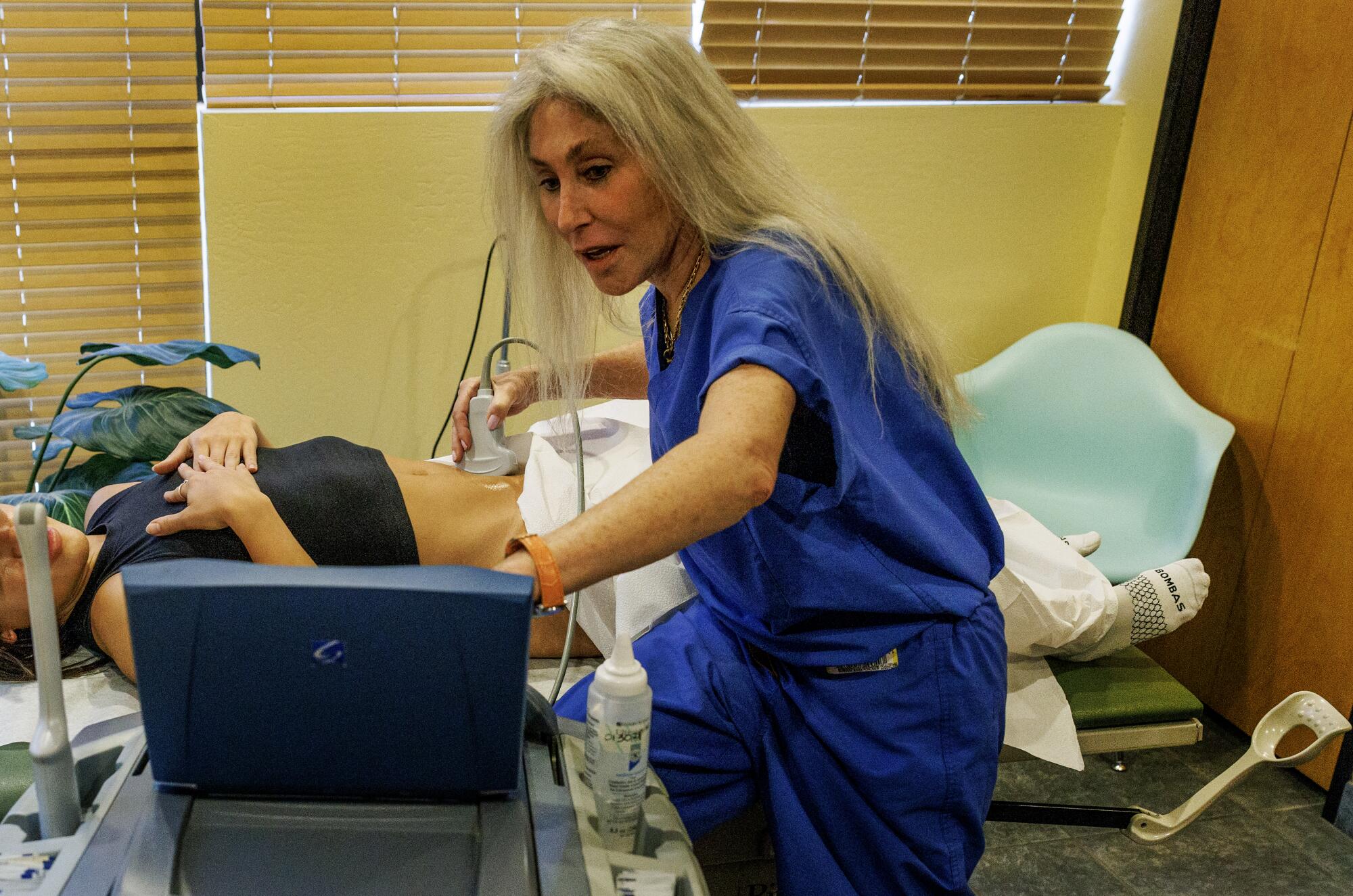 Zipkin performs an ultrasound on a patient.