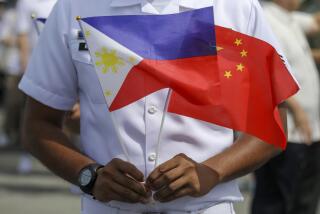 FILE - A member of the Philippine Coast Guard holds flags during the arrival of Chinese naval training ship, Qi Jiguang, for a goodwill visit at Manila's port, Philippines, June 14, 2023. (AP Photo/Basilio Sepe, File)