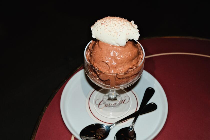 A glass of cream-topped chocolate French mousse with two spoons at Coucou West Hollywood.